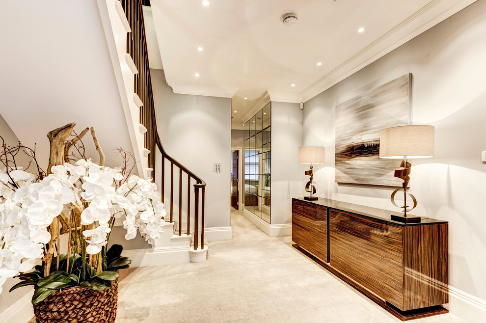 Inspiration for a large contemporary hallway in London with beige walls and carpet.