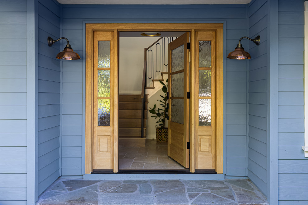 Example of a mid-sized farmhouse travertine floor entryway design in San Francisco with a medium wood front door