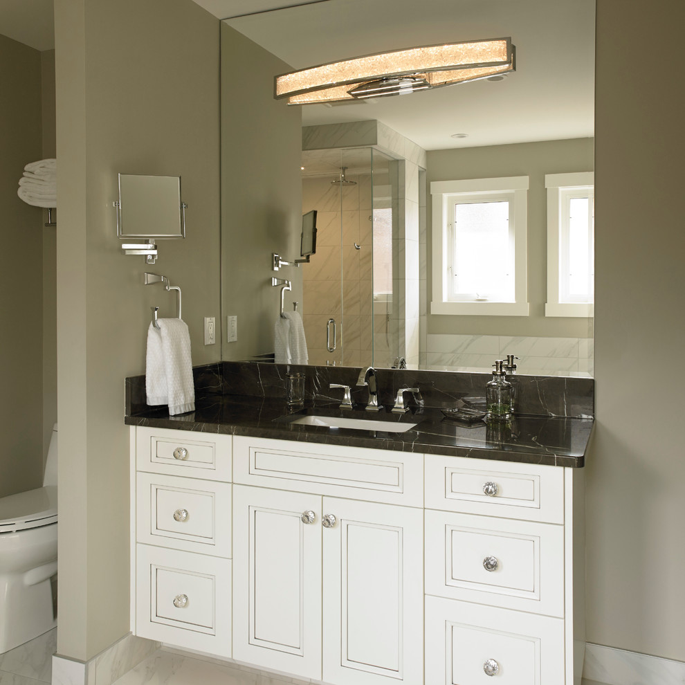 Inspiration for a large transitional master bathroom in Calgary with recessed-panel cabinets, a drop-in tub, a one-piece toilet, an undermount sink, marble benchtops, white cabinets, a corner shower, black tile, stone slab, green walls, marble floors, white floor and a hinged shower door.
