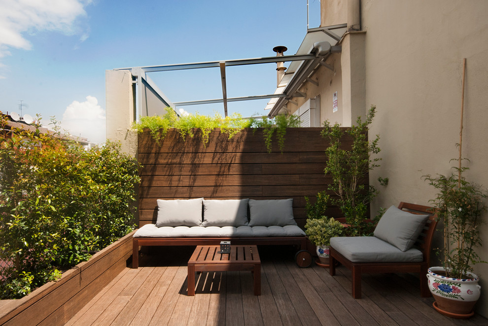 Design ideas for a mid-sized tropical rooftop and first floor deck in Barcelona with a container garden and no cover.