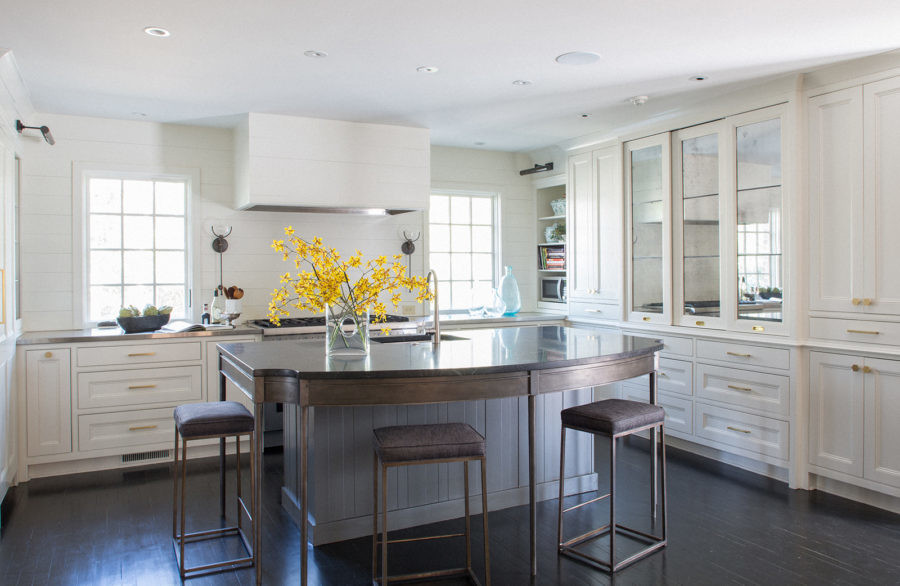 Large transitional u-shaped dark wood floor enclosed kitchen photo with an undermount sink, recessed-panel cabinets, white cabinets, granite countertops, white backsplash, stainless steel appliances and an island
