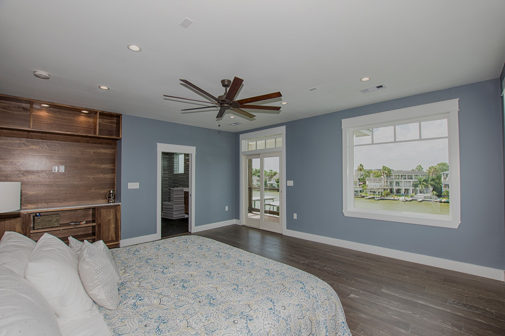 Inspiration for a large beach style master bedroom in Houston with blue walls, medium hardwood floors, no fireplace and brown floor.