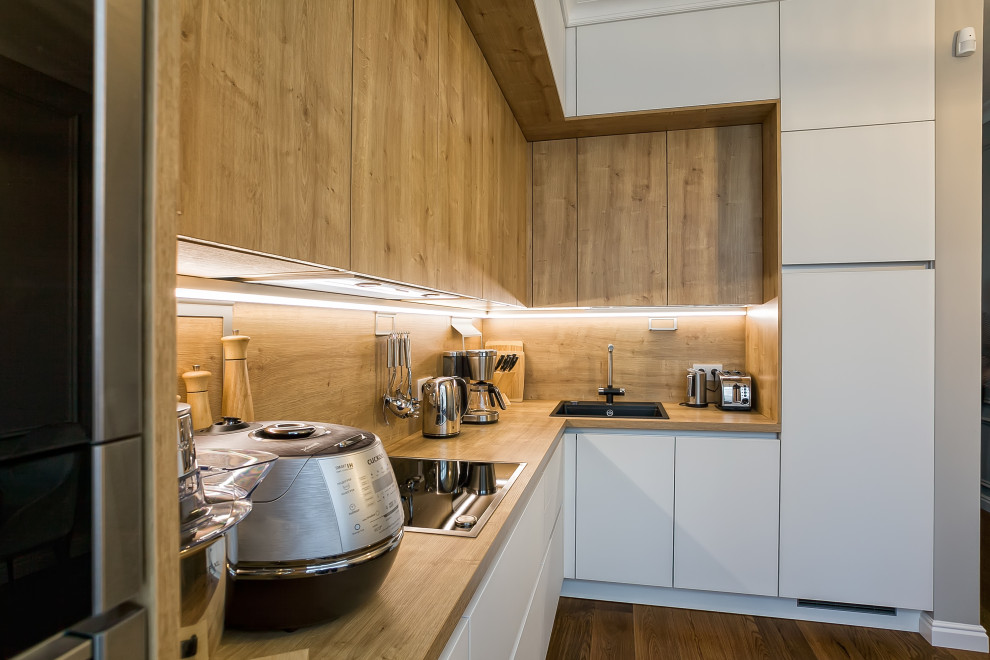 Idéer för att renovera ett stort minimalistiskt brun brunt kök, med en enkel diskho, luckor med glaspanel, vita skåp, laminatbänkskiva, brunt stänkskydd, svarta vitvaror, målat trägolv och brunt golv