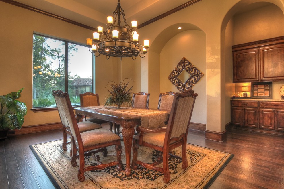 Inspiration for a large mediterranean separate dining room in Houston with beige walls, dark hardwood floors and no fireplace.
