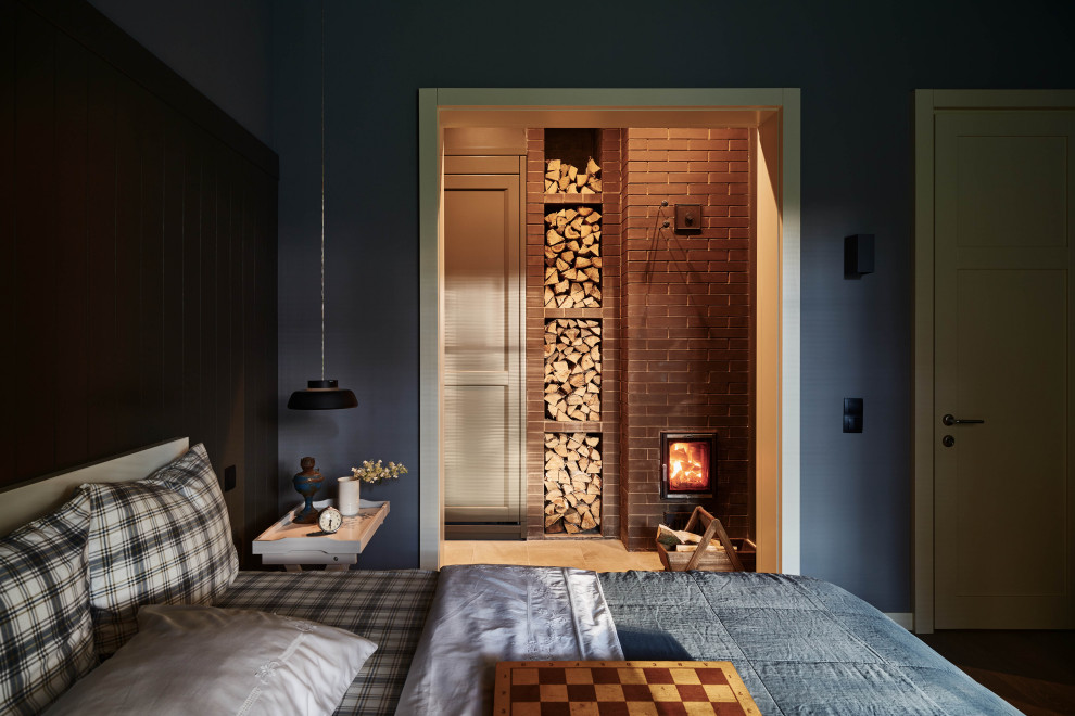 На фото: маленькая хозяйская спальня в стиле кантри с серыми стенами, паркетным полом среднего тона, стандартным камином, фасадом камина из каменной кладки и серым полом для на участке и в саду с
