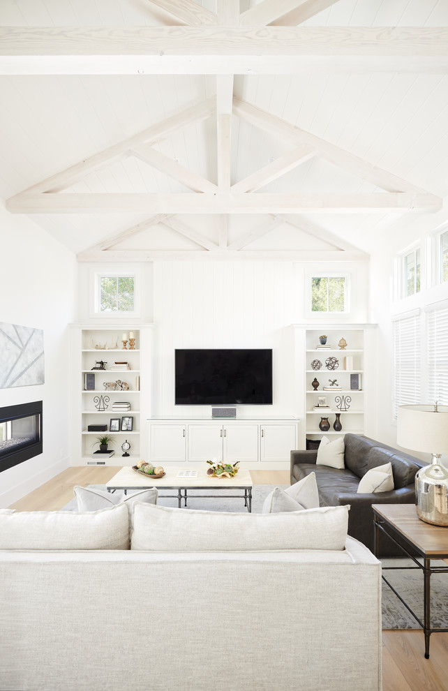 Example of a country open concept light wood floor and beige floor living room design in San Francisco with white walls, a two-sided fireplace and a wall-mounted tv