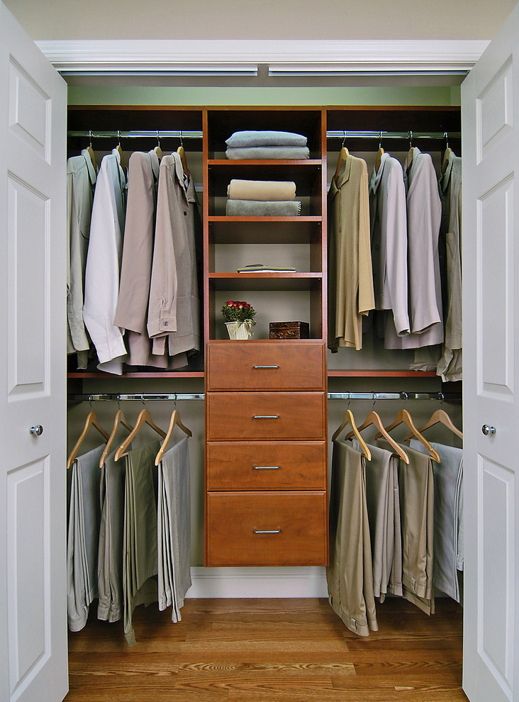 Photo of a mid-sized traditional gender-neutral built-in wardrobe in Burlington with open cabinets, brown floor and laminate floors.
