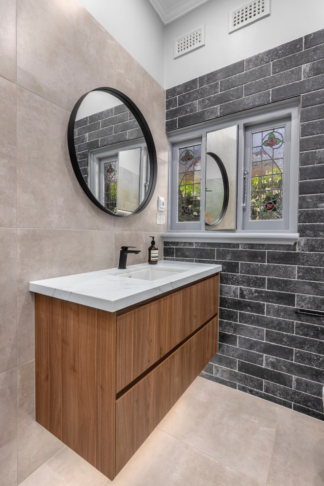 Design ideas for a mid-sized contemporary 3/4 bathroom in Melbourne with furniture-like cabinets, engineered quartz benchtops, a single vanity, a floating vanity, medium wood cabinets, an open shower, beige walls, porcelain floors, beige floor, an open shower, a one-piece toilet, gray tile, porcelain tile, an undermount sink and white benchtops.