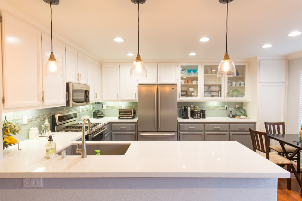 Design ideas for a modern kitchen in Sacramento with an undermount sink, grey cabinets, quartz benchtops, green splashback, glass tile splashback, stainless steel appliances and a peninsula.