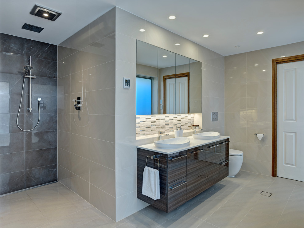 Inspiration for a large contemporary master bathroom in Other with a vessel sink, dark wood cabinets, a freestanding tub, an open shower, beige tile, porcelain tile, beige walls and porcelain floors.
