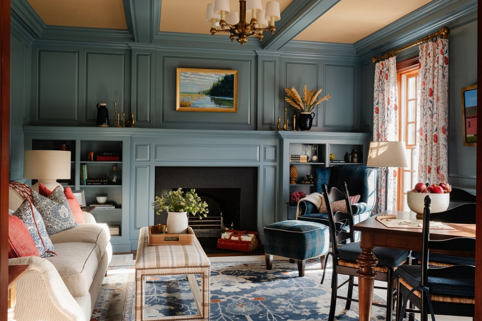 Photo of a traditional family room in Boston with a library, blue walls, carpet, a standard fireplace, a stone fireplace surround, no tv, multi-coloured floor and decorative wall panelling.