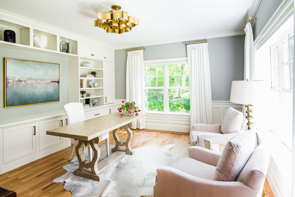 Cette image montre un bureau traditionnel avec un mur gris, un sol en bois brun, aucune cheminée, un bureau indépendant, un sol marron, du lambris et boiseries.