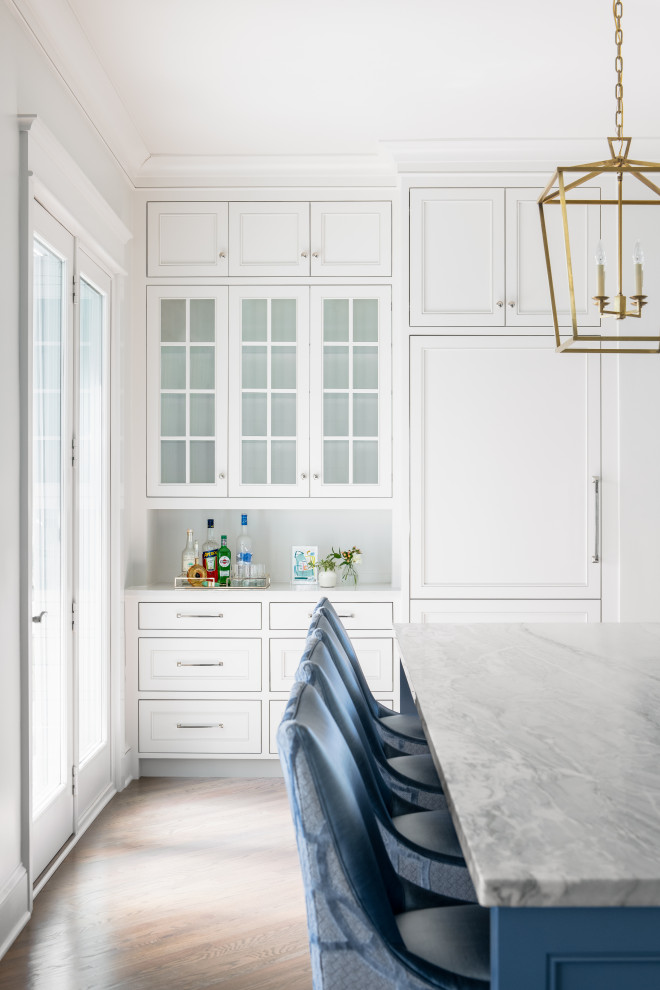 Photo of a beach style eat-in kitchen in Charleston with a farmhouse sink, white cabinets, marble benchtops, blue splashback, mosaic tile splashback, stainless steel appliances, medium hardwood floors and with island.