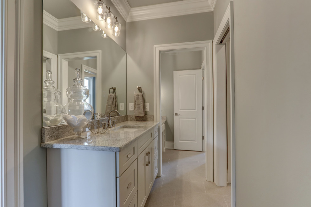 This is an example of a large traditional bathroom in Other with recessed-panel cabinets, grey cabinets, porcelain floors, an undermount sink, granite benchtops and grey benchtops.