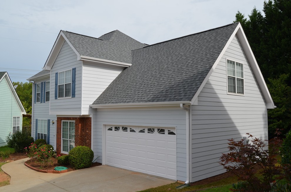 Photo of a mid-sized two-storey grey house exterior in Atlanta with concrete fiberboard siding, a gable roof and a shingle roof.