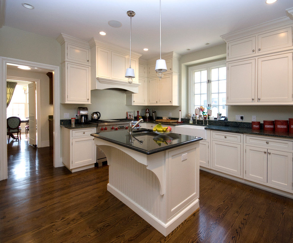 Photo of a mid-sized traditional l-shaped separate kitchen in Chicago with a farmhouse sink, shaker cabinets, white cabinets, granite benchtops, stainless steel appliances, dark hardwood floors and with island.