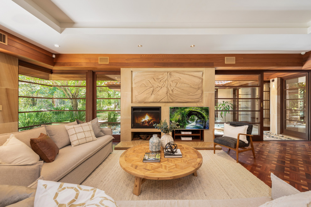Large contemporary open concept living room in Brisbane with brown walls, a standard fireplace, a tile fireplace surround, a wall-mounted tv and brown floor.