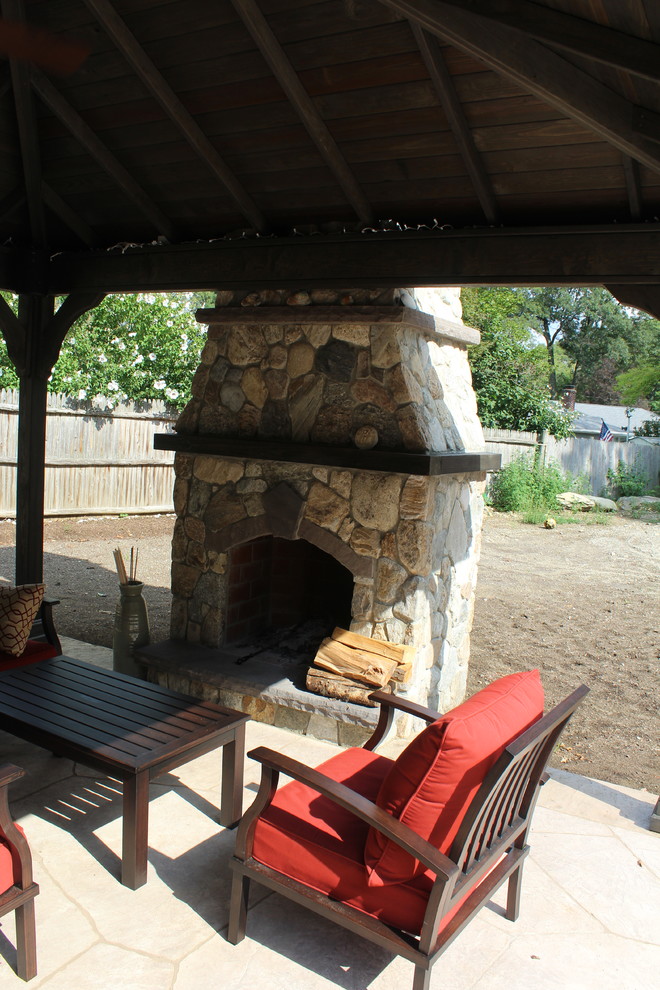 This is an example of a large transitional backyard patio in Boston with an outdoor kitchen, natural stone pavers and a gazebo/cabana.