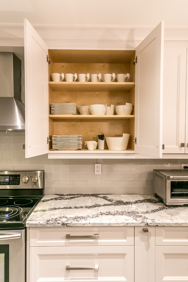 Large transitional gray floor enclosed kitchen photo in Toronto with an undermount sink, recessed-panel cabinets, white cabinets, quartz countertops, white backsplash, ceramic backsplash, stainless steel appliances and an island