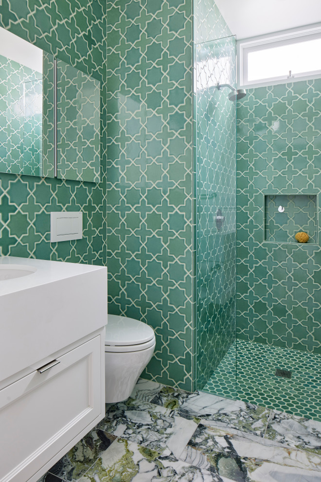 Источник вдохновения для домашнего уюта: главная ванная комната в современном стиле с фасадами островного типа, белыми фасадами, инсталляцией, керамической плиткой, полом из ламината, монолитной раковиной, столешницей из гранита, белой столешницей, тумбой под одну раковину, подвесной тумбой, душем без бортиков, зеленой плиткой, зелеными стенами, зеленым полом и душем с распашными дверями