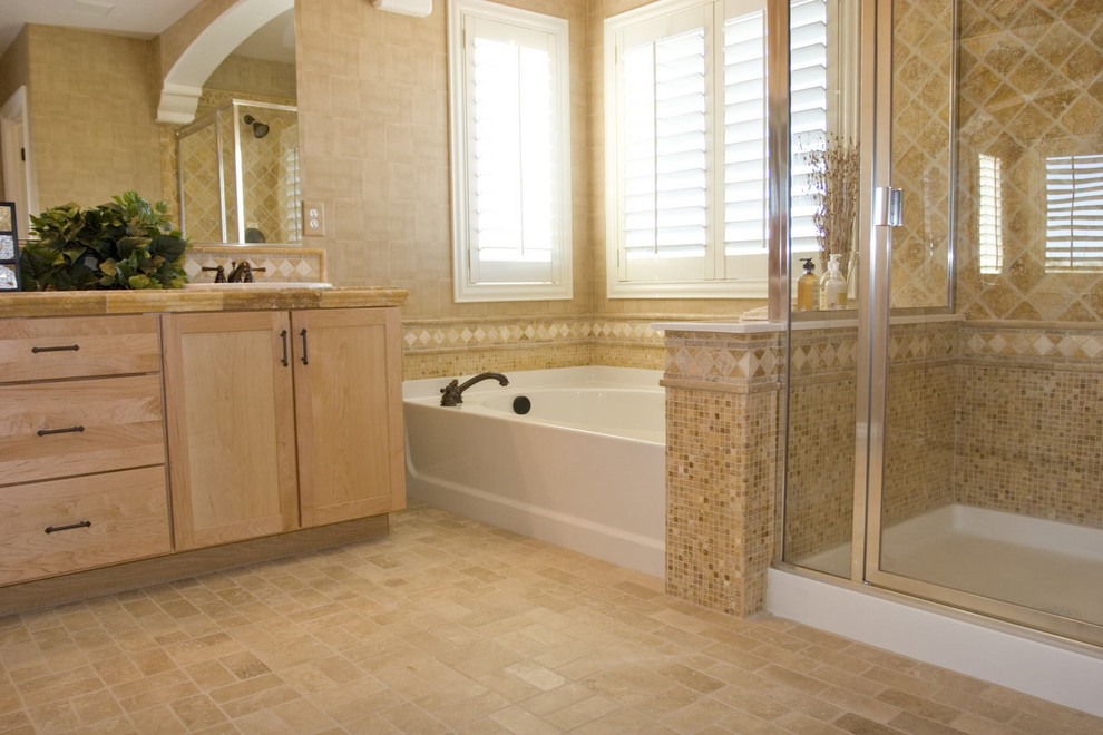 Inspiration for a mid-sized traditional master bathroom in Other with recessed-panel cabinets, light wood cabinets, a drop-in tub, a corner shower, beige tile, travertine, beige walls, travertine floors, a drop-in sink, tile benchtops, beige floor, a hinged shower door and beige benchtops.