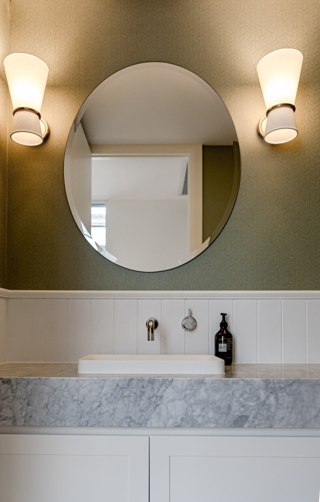 Esempio di una stanza da bagno tradizionale di medie dimensioni con ante in stile shaker, ante bianche, top in marmo, un lavabo, mobile bagno incassato e carta da parati