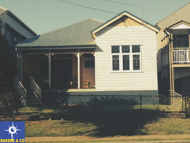 This is an example of a small tropical one-storey white exterior in Brisbane with wood siding.