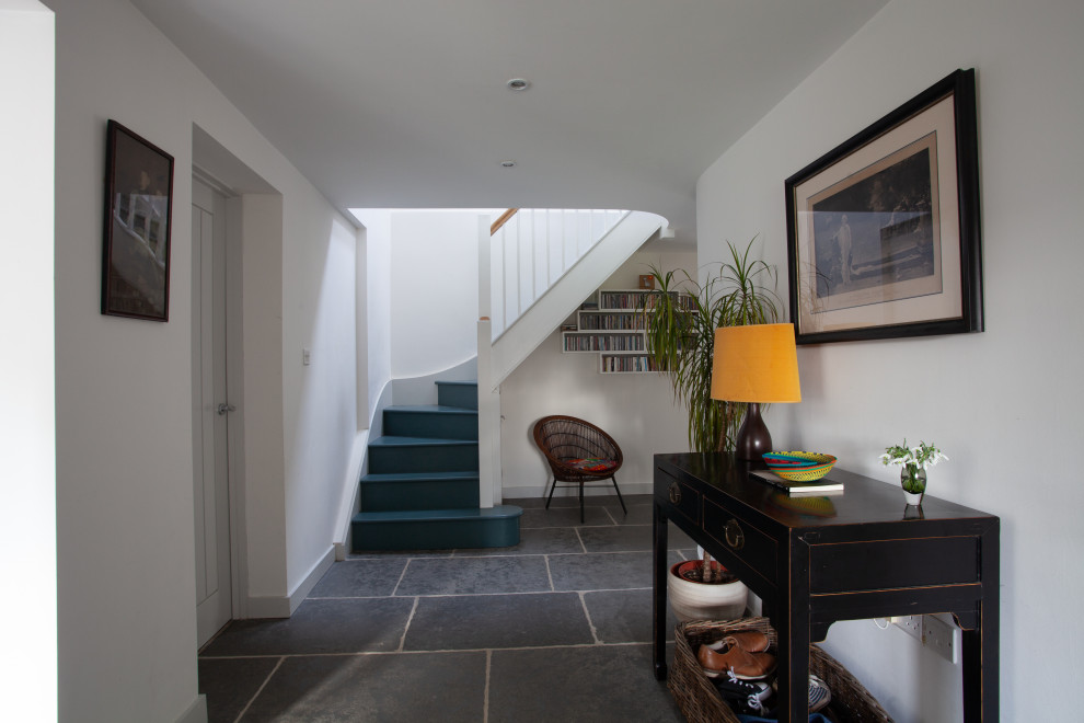 Photo of a mid-sized eclectic hallway in Devon with white walls, limestone floors and grey floor.