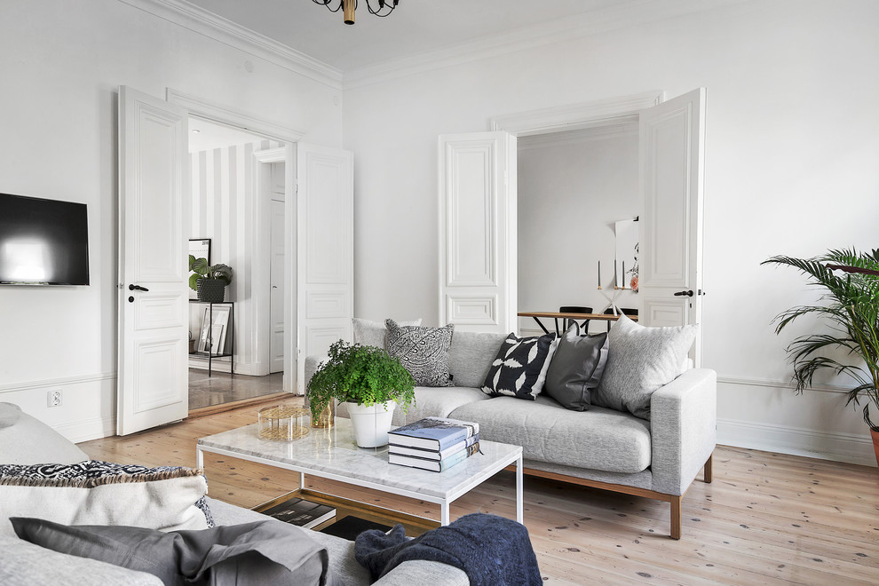 Mid-sized scandinavian formal open concept living room in Stockholm with white walls, light hardwood floors and no tv.