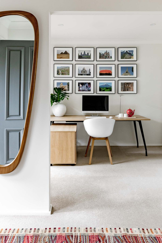 Mittelgroßes Modernes Arbeitszimmer mit Arbeitsplatz, weißer Wandfarbe, Teppichboden, freistehendem Schreibtisch und weißem Boden in Sydney