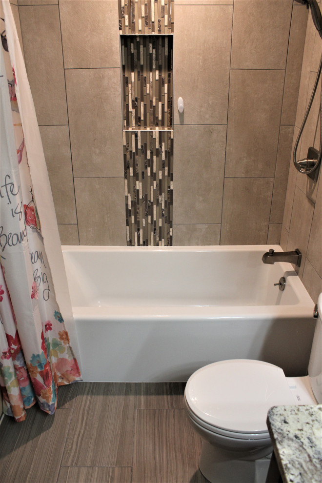 Photo of a mid-sized transitional master bathroom in Detroit with shaker cabinets, brown cabinets, an alcove tub, an alcove shower, beige tile, ceramic tile, beige walls, porcelain floors, an undermount sink, granite benchtops, brown floor, a shower curtain, brown benchtops, a single vanity and a freestanding vanity.