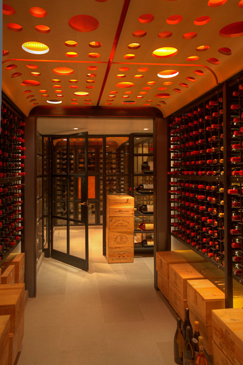 This is an example of a large contemporary wine cellar in New York with limestone floors and storage racks.