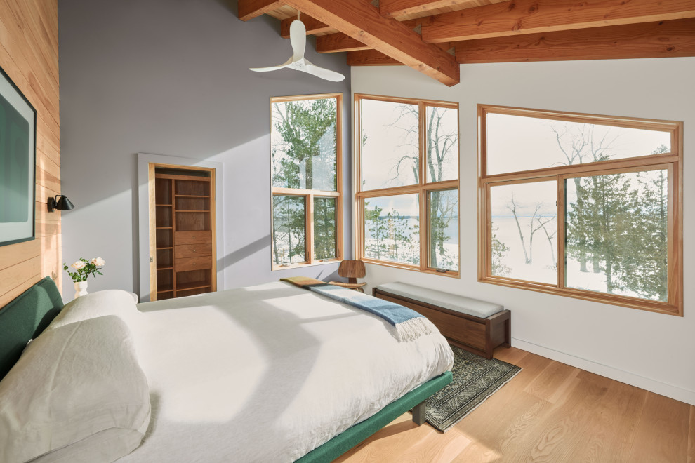 Foto de dormitorio principal rural de tamaño medio con paredes azules, suelo de madera en tonos medios, vigas vistas y madera