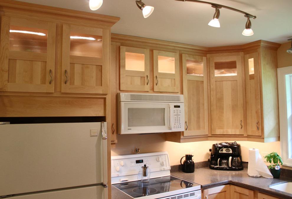 Example of a small transitional l-shaped open concept kitchen design with shaker cabinets, light wood cabinets, laminate countertops, white appliances, an island and gray countertops