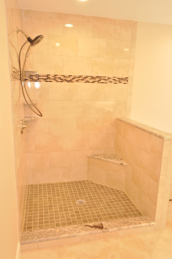 Example of a large transitional master beige tile and porcelain tile porcelain tile drop-in bathtub design in DC Metro with a drop-in sink, raised-panel cabinets, dark wood cabinets, granite countertops and beige walls