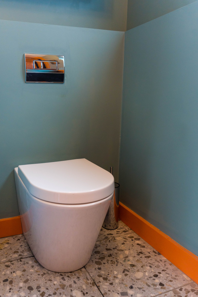 Cette photo montre une petite salle de bain éclectique en bois foncé pour enfant avec un placard à porte vitrée, une baignoire posée, un combiné douche/baignoire, WC à poser, un carrelage orange, des carreaux de céramique, un mur multicolore, un lavabo posé, un plan de toilette en stratifié, un sol gris, un plan de toilette gris, une niche, meuble simple vasque, meuble-lavabo encastré et un sol en terrazzo.
