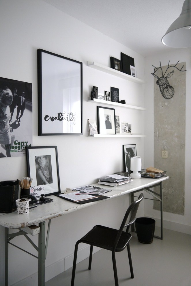 Inspiration for an industrial home office in Amsterdam with white walls, a freestanding desk and grey floor.