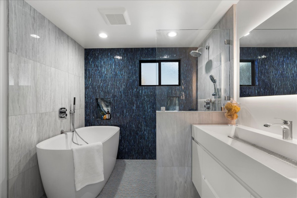 Стильный дизайн: большая детская ванная комната в морском стиле с плоскими фасадами, белыми фасадами, японской ванной, открытым душем, раздельным унитазом, разноцветной плиткой, плиткой мозаикой, разноцветными стенами, полом из галечной плитки, раковиной с несколькими смесителями, столешницей из искусственного камня, синим полом, открытым душем, белой столешницей, нишей, тумбой под одну раковину и подвесной тумбой - последний тренд