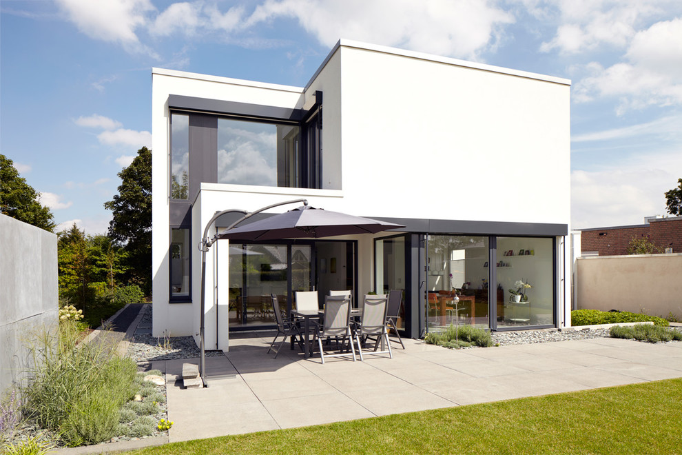 Inspiration for a mid-sized contemporary two-storey white exterior in Cologne with a flat roof.