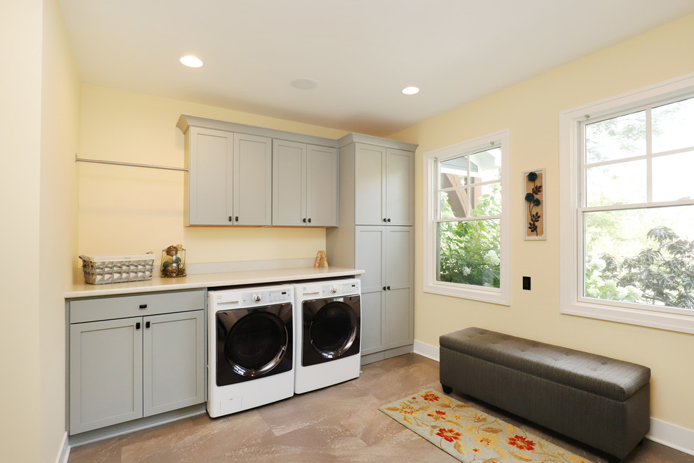 Mid-sized traditional galley utility room in Grand Rapids with shaker cabinets, white cabinets, laminate benchtops, yellow walls, laminate floors, a side-by-side washer and dryer and beige floor.