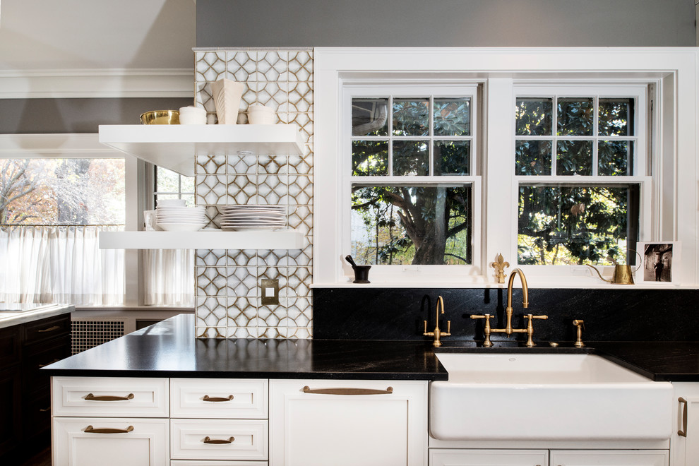 Example of a large transitional u-shaped medium tone wood floor and brown floor eat-in kitchen design with a farmhouse sink, white backsplash, glass tile backsplash, stainless steel appliances, an island, recessed-panel cabinets, white cabinets and marble countertops