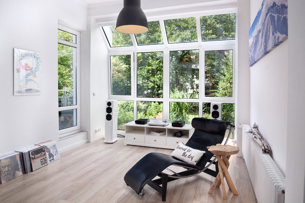 Photo of a mid-sized contemporary enclosed family room in Bremen with a music area, white walls, light hardwood floors, no fireplace and beige floor.
