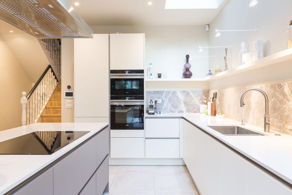 Large contemporary l-shaped kitchen in Other with an undermount sink, flat-panel cabinets, white cabinets, grey splashback, stainless steel appliances, porcelain floors, with island, grey floor and white benchtop.