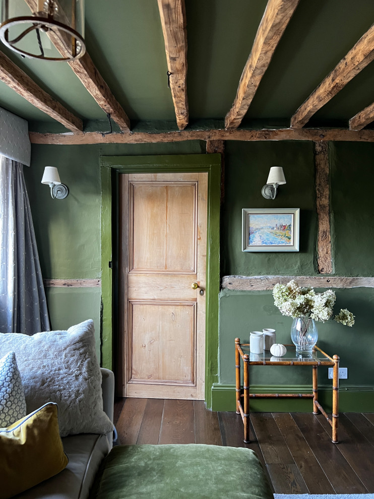 Kleines Country Wohnzimmer mit grüner Wandfarbe, dunklem Holzboden, Kaminumrandung aus Backstein, Multimediawand und braunem Boden in Oxfordshire