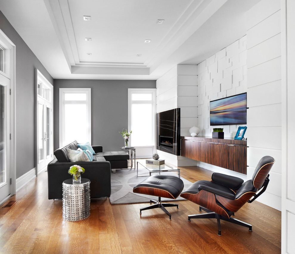 Contemporary family room in Toronto with grey walls and brown floor.