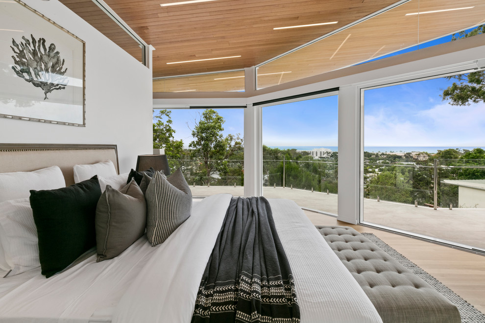 This is an example of a contemporary master bedroom in Sunshine Coast with white walls, light hardwood floors and beige floor.