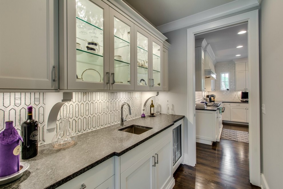 Example of a transitional dark wood floor kitchen design in Chicago with an undermount sink, white cabinets, granite countertops, white backsplash and stone tile backsplash