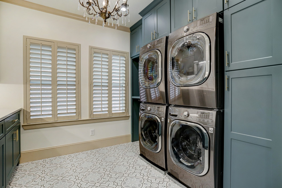 Photo of a large traditional galley dedicated laundry room in Houston with a drop-in sink, shaker cabinets, turquoise cabinets, quartzite benchtops, multi-coloured splashback, ceramic splashback, white walls, ceramic floors, a stacked washer and dryer, multi-coloured floor and white benchtop.