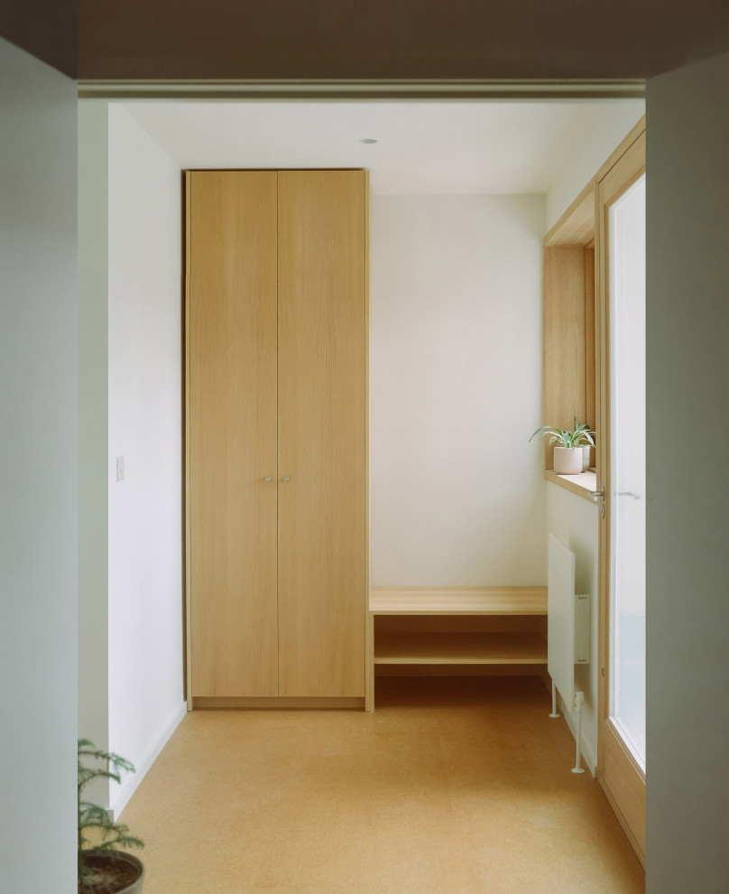 Idée de décoration pour une entrée design de taille moyenne avec un couloir, un mur blanc, un sol en liège, une porte simple et une porte en bois brun.