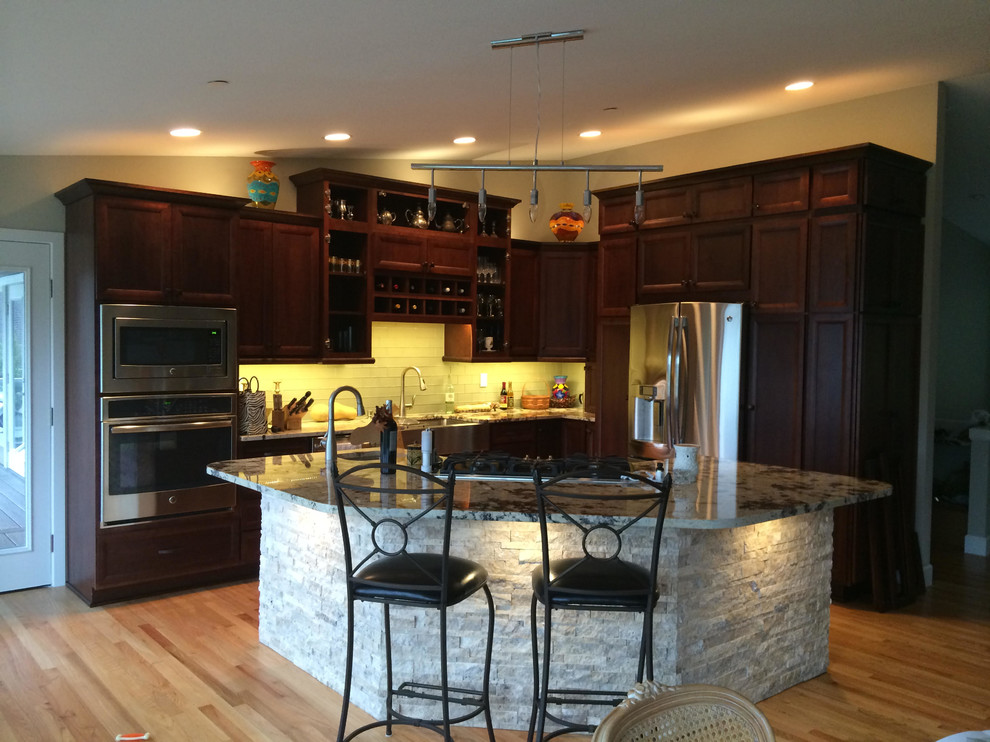 Inspiration for a mid-sized l-shaped eat-in kitchen remodel in Seattle with raised-panel cabinets, dark wood cabinets and an island